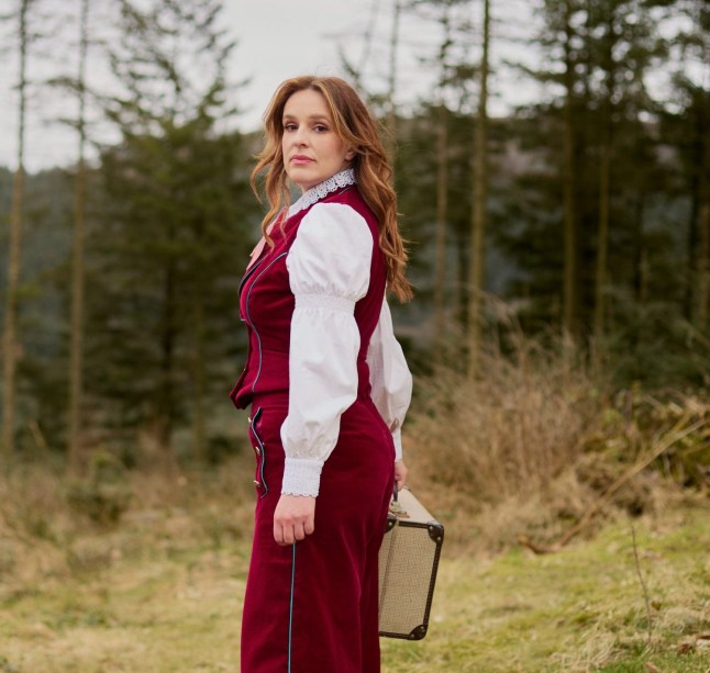 Katie Norris poseerib kohvrit hoides