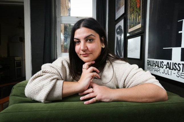 Almara Abgaria, kes puhkab mõlemad käed kodus rohelisel diivanil (pilt: Rachel Adams 2023)