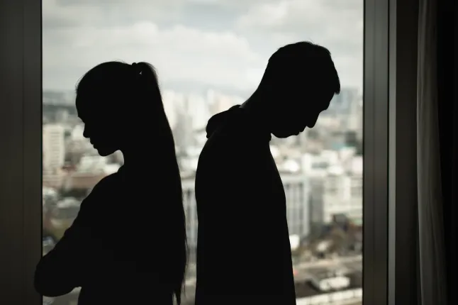 Kurva mehe ja naise siluett, mis seisavad vastamisi, näitavad emotsionaalset distantsi, suhete konflikti, lahkuminekut.