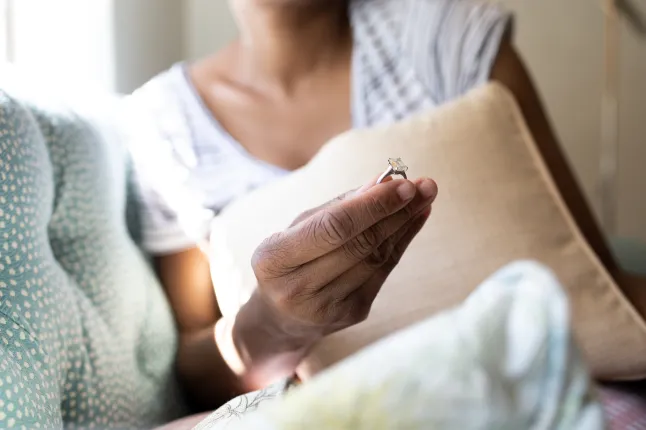must naine hoiab käes teemantkihlasõrmust