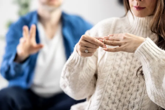 Ärritatud depressioonis noor naine, kes hoiab abielusõrmust siseruumides, kihluse katkestamine, suhte lõpetamine, hüljatud naine, rasket otsust tegemas petetud pruut, murtud süda, lahkumineku ja lahutuse idee