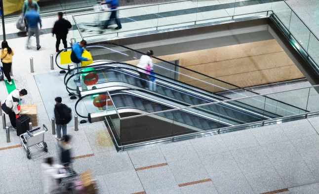 Inimeste rühm, kes kasutab lennujaama eskalaatoreid