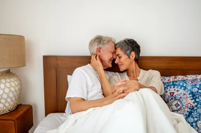 Armastav eakas paar hubases ja mugavas magamistoas