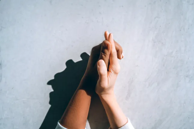 Rahvusvaheliste paaride sümbol, kes hoiavad käest vastu halli betoonseina