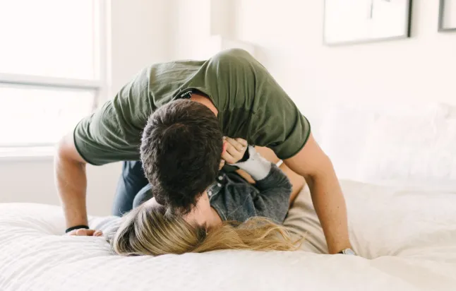 Paar lõõgastub voodis, suudleb