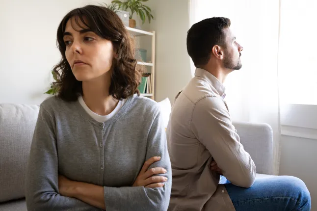 Noorpaar istub pärast kodus vaidlust seljad vastamisi diivanil.