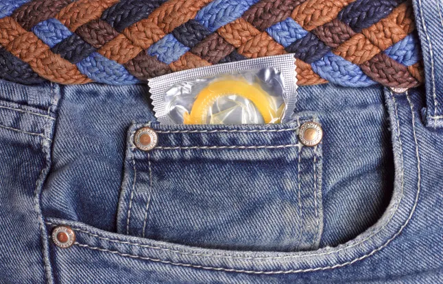 Kondoom teksapükste taskus lähedalt