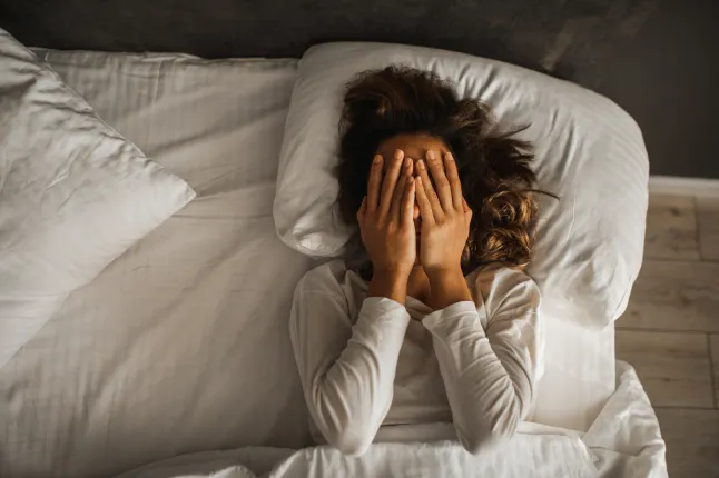 Depressioonis naine sulges kätega näo ja nuttis voodis. Melanhoolne meeleolu, vaimne tervis. Eluprobleemid