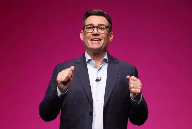 Andy Burnham räägib lilla tausta ees